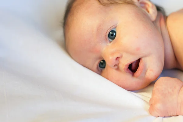 Newborn baby lying on a white background — Stockfoto