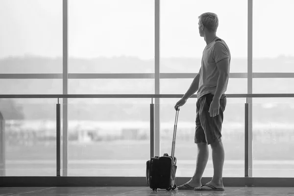 Man with suitcase waiting a plane at terminal airport — Zdjęcie stockowe