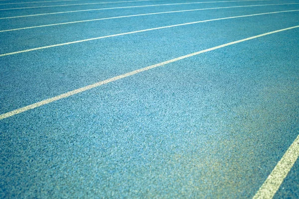 Фон синей дорожки для бега на стадионе — стоковое фото