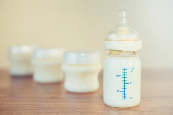 Babyflasche mit Milch und Messwaage Stockfoto