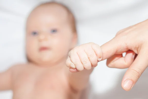 Newborn baby holding her mother's finger — Stok fotoğraf