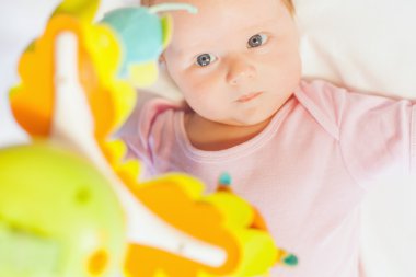 happy baby playing with children's musical mobile toy