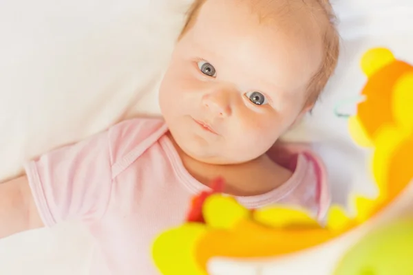 Happy baby playing with children's musical mobile toy — Stock Photo, Image