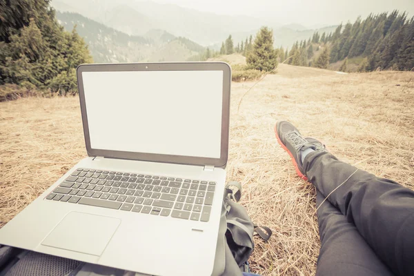 Tourist uses laptop remotely and relax at mountain — Zdjęcie stockowe