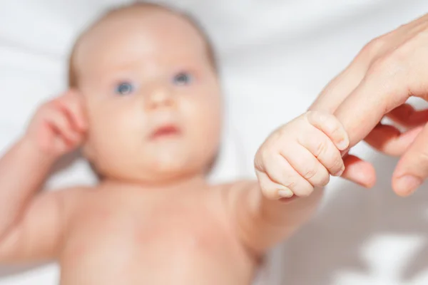 Newborn baby holding her mother's finger — Stok fotoğraf