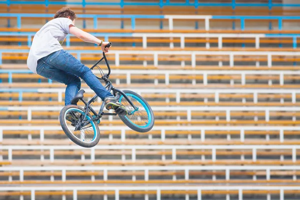 Adolescente em uma bicicleta em um salto em altura — Fotografia de Stock
