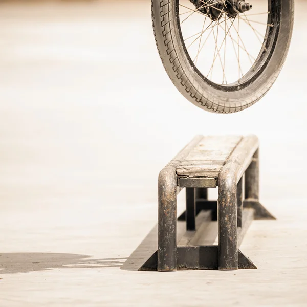 Close-up of bicycle wheels doing trick by rail — Zdjęcie stockowe