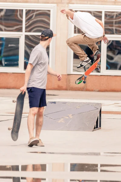 Handsome guys riding and doing trick by skateboard — Zdjęcie stockowe