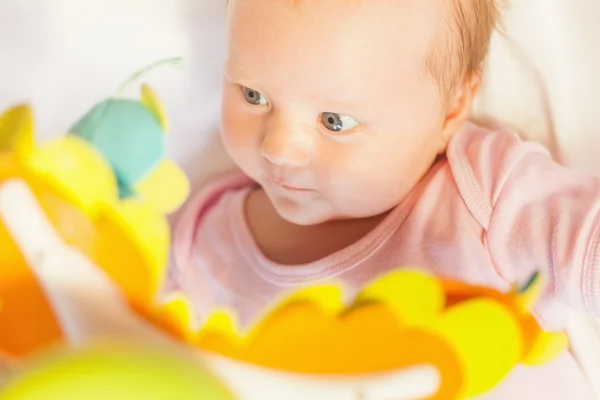 Happy baby playing with children's musical mobile toy — Stock Photo, Image