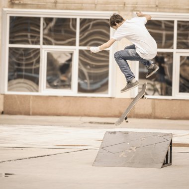 handsome guy doing trick by skateboard
