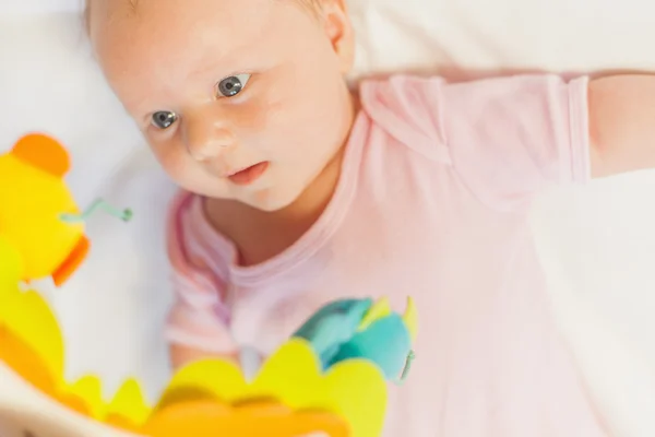 Happy baby playing with children's musical mobile toy — Stock Photo, Image