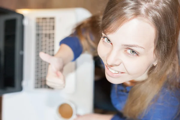 Beautiful successful woman looking at the camera and uses laptop — Zdjęcie stockowe