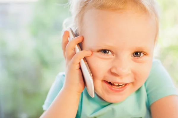 Beautiful little child talking by mobile phone with her mother — Stock Photo, Image