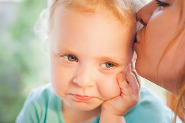 Mom kissing pretty daughter, with beautiful eyes and blonde hair — Stockfoto