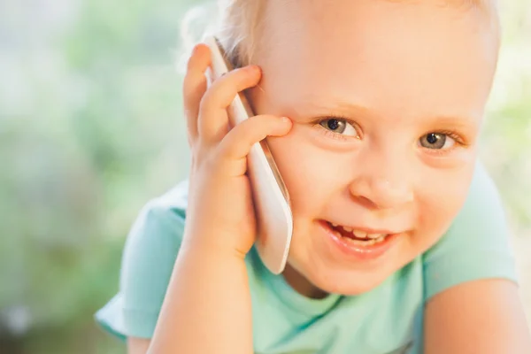 Beautiful little child talking by mobile phone with her mother — Stock Photo, Image