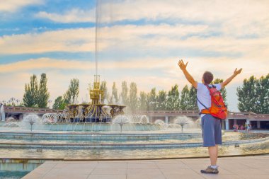 Young tourist on the fountain in National Park, Almaty