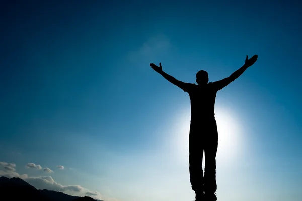 Silhouette of climbing young adult at the top of summit — Stock Photo, Image