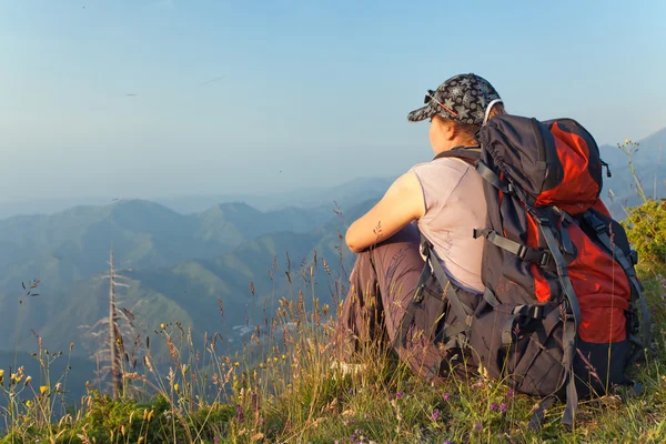 Een jonge vrouw in de bergen bij zonsondergang — Stockfoto