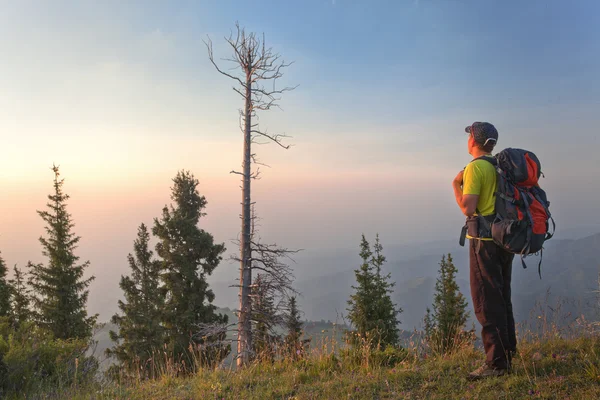 A young man in the mountains at sunset — Stock Photo, Image