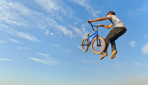 Um adolescente pulando em uma bicicleta . — Fotografia de Stock