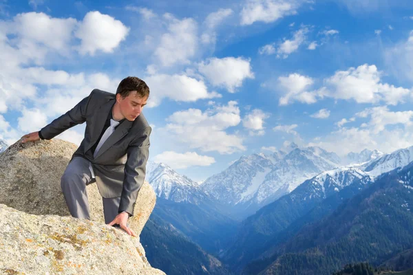 Jeune homme d'affaires regardant du haut de la montagne — Photo