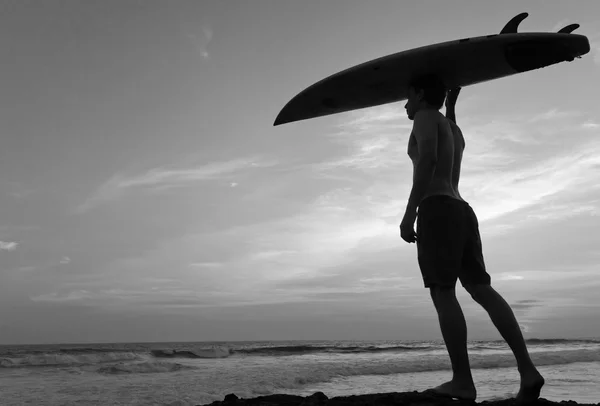 Homme surfeur avec planche de surf sur une côte. Bali. Indonésie — Photo