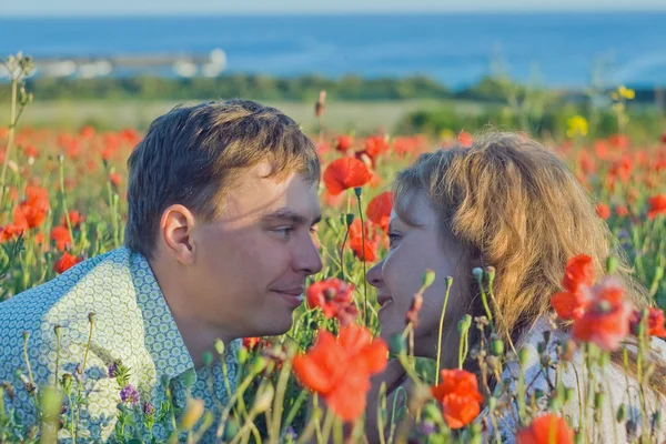 Yong casal com flores perto do mar . — Fotografia de Stock