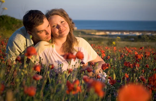 Belo casal mulheres jovens e homem jovem em flores — Fotografia de Stock