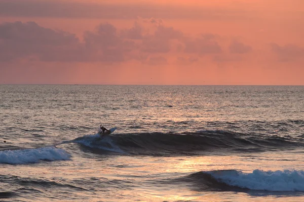 Gün batımında okyanus dalga sürme sörfçü — Stok fotoğraf