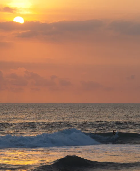 Surfista cabalgando al atardecer en Ocean Wave — Foto de Stock