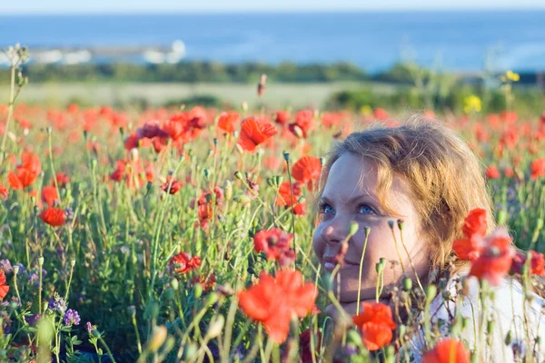 Chica con flores cerca del mar . Imágenes de stock libres de derechos