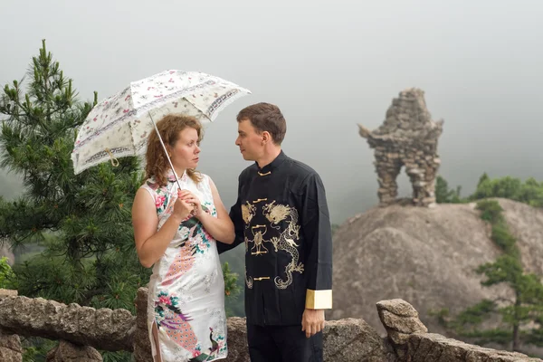Το υπέροχο ζευγάρι με ομπρέλα σε συννεφιά πάνω από το κινεζικό βουνό Huangshan — Φωτογραφία Αρχείου