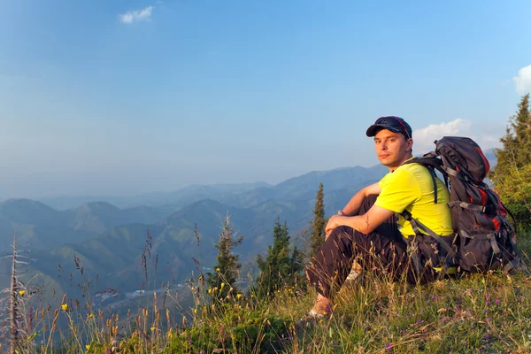 Um jovem nas montanhas ao pôr-do-sol — Fotografia de Stock
