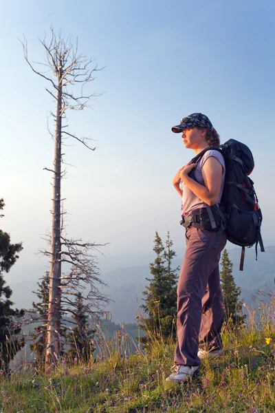 A young woman in the mountains at sunset — Stock Photo, Image