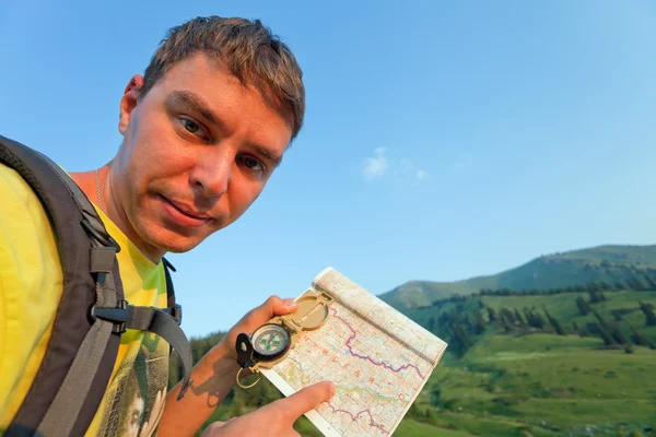 Tourist with a map and compass in the mountains of Switzerland. — Stock Photo, Image