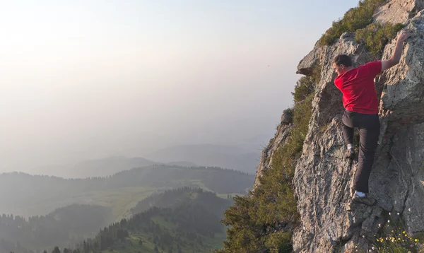 Genç bir adam tepeye tırmanma — Stok fotoğraf