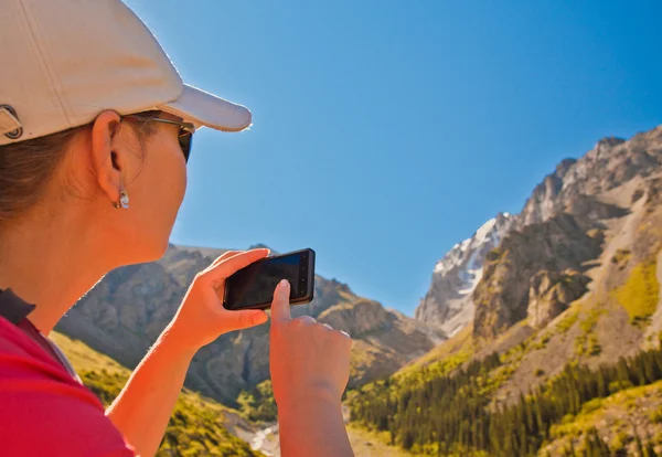 Girl-traveler using mobile in the mountains. — Stock Photo, Image