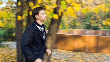 Genç adam ormanda koşuyor.