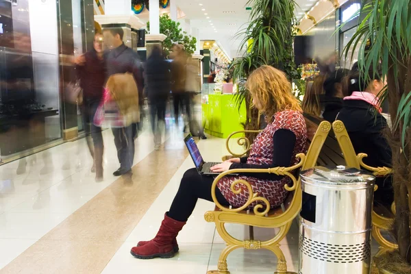 Woman working on laptop in the mall — Stock Photo, Image