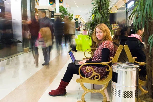 Mulher trabalhando no laptop no shopping — Fotografia de Stock