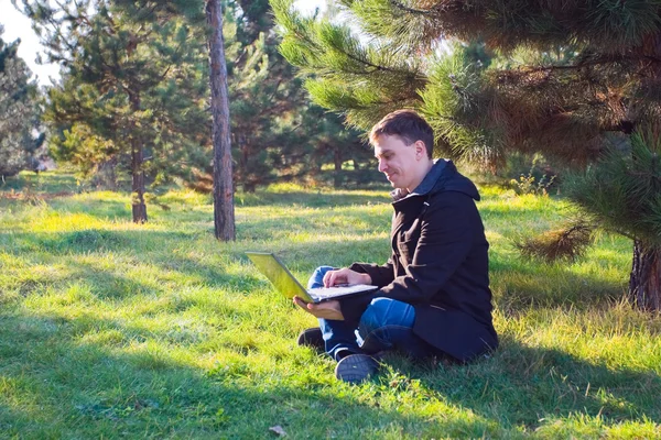 Businessman working on laptop in the park — Stock Photo, Image