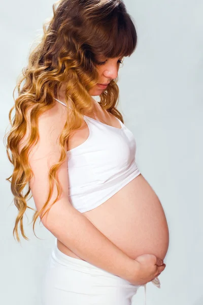 Mulher grávida no fundo branco — Fotografia de Stock