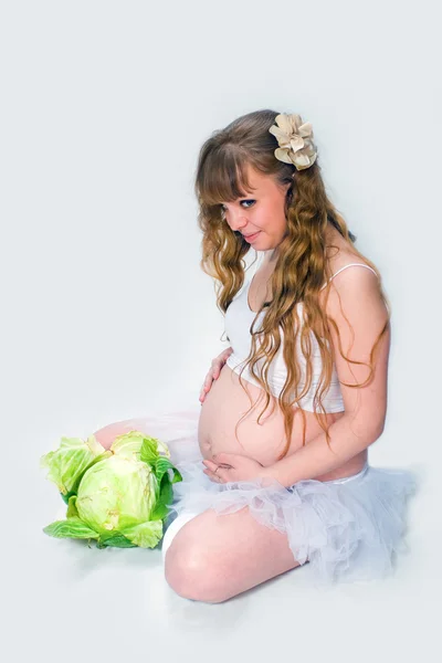 Беременная женщина на белом фоне. — стоковое фото