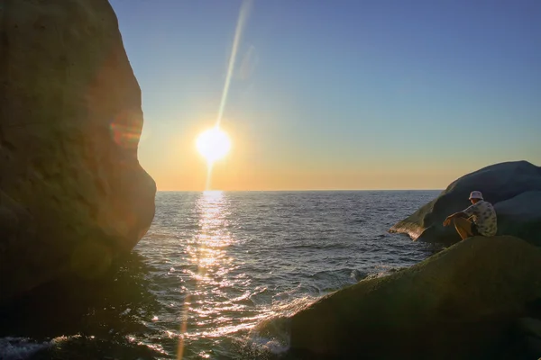 Turista desfrutando do pôr do sol sobre o mar . — Fotografia de Stock