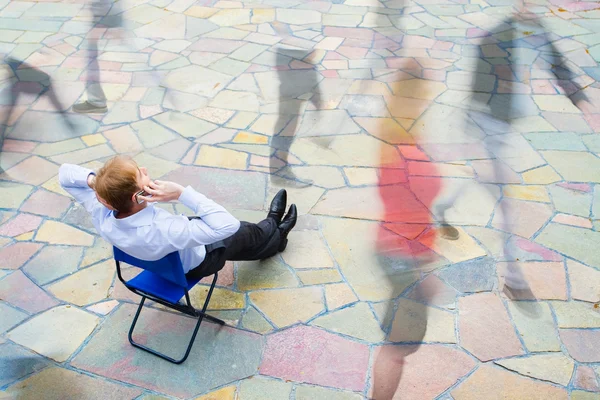 En affärsman sitter och ringer gatan — Stockfoto