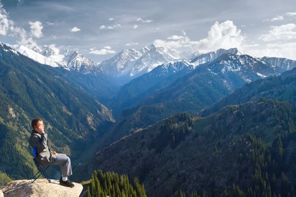 De zakenman op de top van de berg is praten over nieuwe — Stockfoto