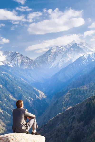 El hombre de negocios en la cima de la montaña sentado y pensando — Foto de Stock