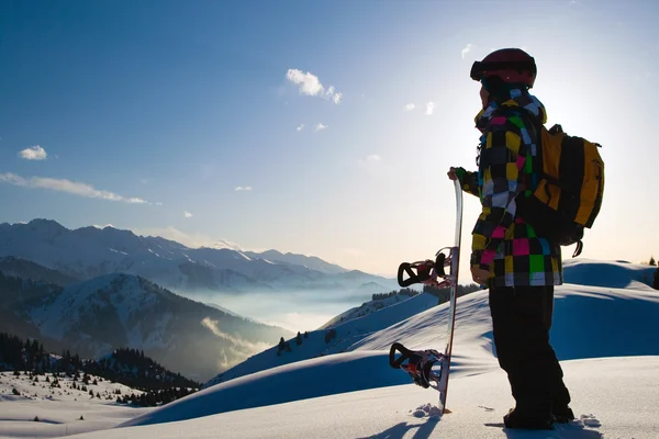 Sport man in snowy mountains at sunset — Stock Photo, Image