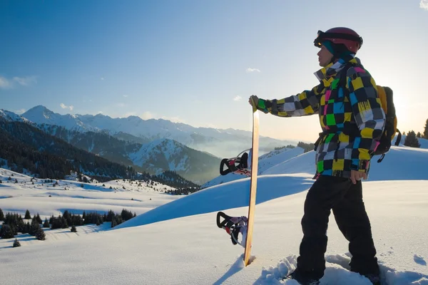 Sport man in snowy mountains at sunset — Stock Photo, Image