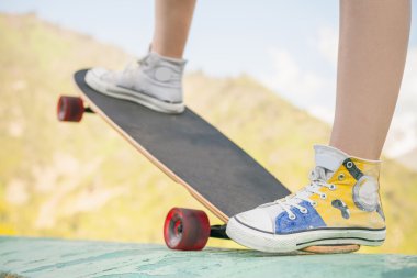 teenager doing a trick by skateboard outdoor at mountain